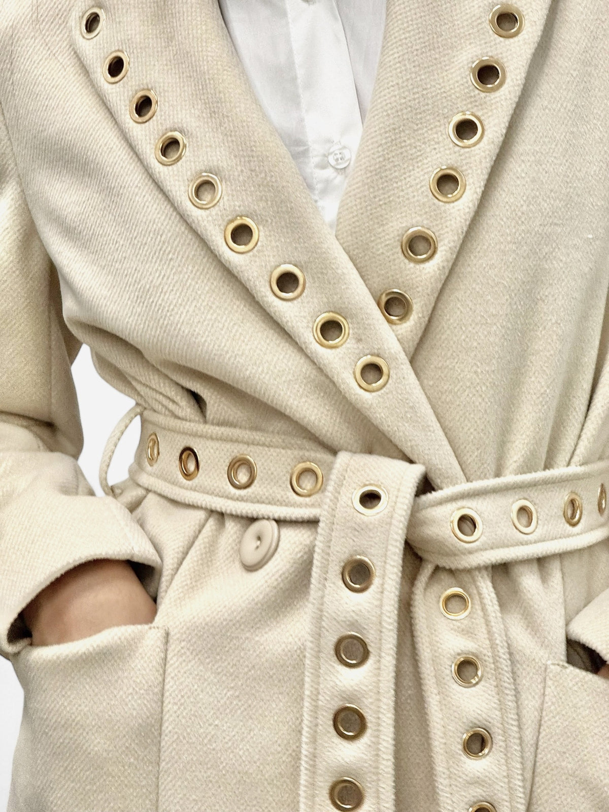 Cappotto beige lungo con spacchi laterali e applicazione occhielli